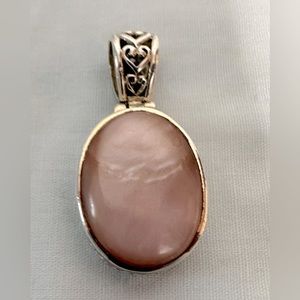 Silver pendant with a pink stone.